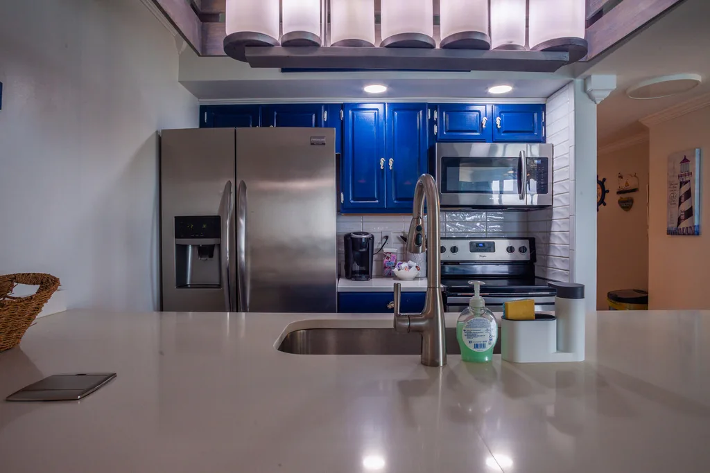 Kitchen with blue cabinetry and stainless steel appliances