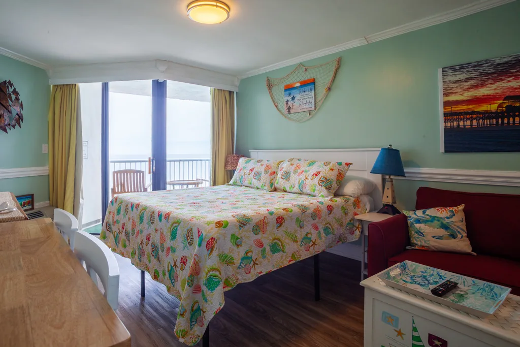 King bed beside the oceanfront balcony door in Shirley's studio